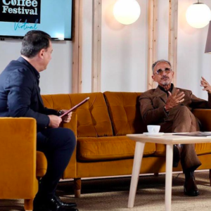 Jeffrey Young interviewing Kamal Bengougam for The Global Coffee Festival. Sitting on a yellow couch with coffee in the foreground.